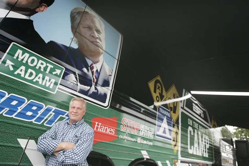 FootballR - NFL - Diese Beschreibung wurde automatisch generiert. Ein Mann, der vor einem grün-weißen Bus steht, ist NFL-Analyst Chris Mortensen von ESPN.