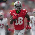 FootballR - NFL - Diese Beschreibung wurde automatisch generiert. Der Ohio State Wide Receiver, Marvin Harrison Jr., läuft mit einem Football in der Hand.