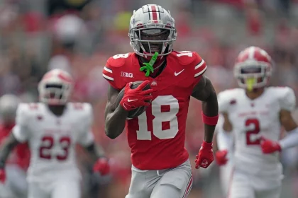 FootballR - NFL - Diese Beschreibung wurde automatisch generiert. Der Ohio State Wide Receiver, Marvin Harrison Jr., läuft mit einem Football in der Hand.