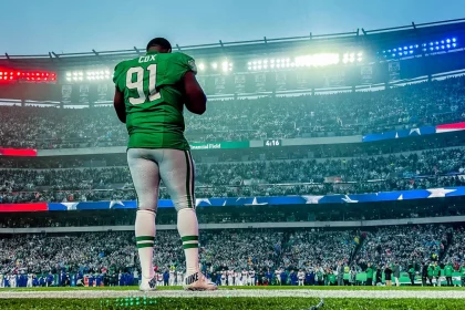 FootballR - NFL - Diese Beschreibung wurde automatisch generiert. Ein Eagles-Footballspieler, Fletcher Cox, steht auf einem Feld in einem Stadion.