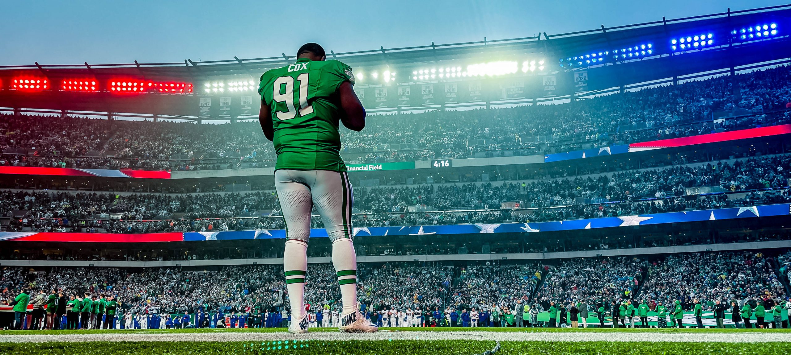 FootballR - NFL - Diese Beschreibung wurde automatisch generiert. Ein Eagles-Footballspieler, Fletcher Cox, steht auf einem Feld in einem Stadion.