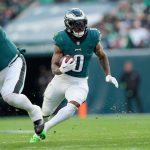 FootballR - NFL - Diese Beschreibung wurde automatisch generiert. Die Philadelphia Eagles mit D'Andre Swift laufen mit dem Ball.