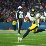 FootballR - NFL - Diese Beschreibung wurde automatisch generiert. Diontae Johnson läuft mit einem Ball.