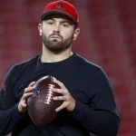 NFC South - Wild Card: FootballR Pro Bowl 2025 - NFL Week 8 - Diese Beschreibung wurde automatisch generiert. Ein Footballspieler, Baker Mayfield, hält einen Football in einem Buccaneers-Stadion.