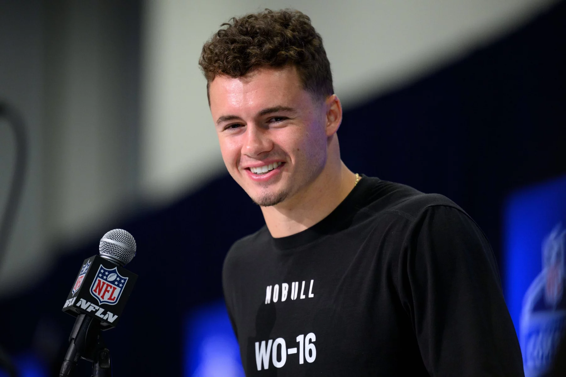 FootballR - NFL Combine - Diese Beschreibung wurde automatisch generiert. Ladd McConkey - Ein Wide Receiver der University of Georgia lächelt, während er ein Mikrofon hält.