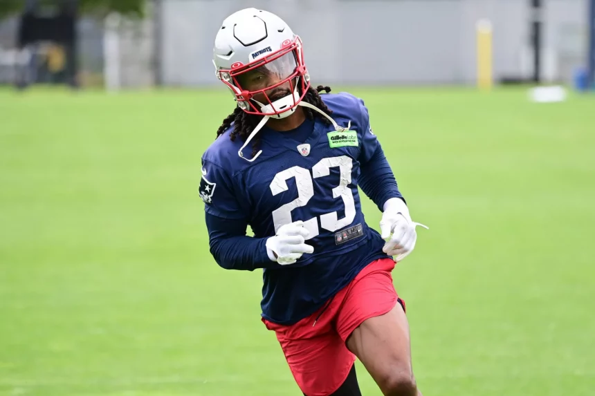 FootballR - NFL - Kyle Dugger, ein American-Football-Safety für die New England Patriots, trägt die Nummer 23, trainiert auf dem Feld, trägt einen weißen Helm, ein blaues Trikot und rote Shorts, konzentriert und Diese Beschreibung wurde automatisch generiert.