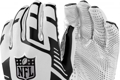 FootballR - Receiver Handschuhe - Wilson NFL Stretch Fit Receiver Handschuhe - Das Bild zeigt ein Paar weiße und schwarze Wilson NFL-Receiverhandschuhe. Ein Handschuh zeigt die Rückseite mit dem NFL-Logo deutlich sichtbar in der Mitte, was an den Wilson NFL Duke Replica-Football erinnert, während der andere Handschuh mit der Handfläche nach oben gezeigt wird und ein gepunktetes Griffmuster aufweist. Der Handgelenkbereich trägt das „Wilson“-Logo in Schwarz auf weißem Hintergrund. Diese Beschreibung wurde automatisch generiert.