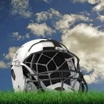 FootballR - NFL BYE Weeks - Bye Week - Woche 7 - Welches Teams hat wann Bye Week? - Ein weißer Footballhelm mit schwarzen Akzenten liegt auf einem grünen Grasfeld unter einem teilweise bewölkten blauen Himmel, als wäre er bereit für die nächste Bye Week. Die Gesichtsmaske des Helms ist schwarz mit einem Gittermuster und das schlanke, moderne Design fällt auf. Kleine Pflanzen rund um das Gras ergänzen die natürliche Kulisse. Diese Beschreibung wurde automatisch generiert.