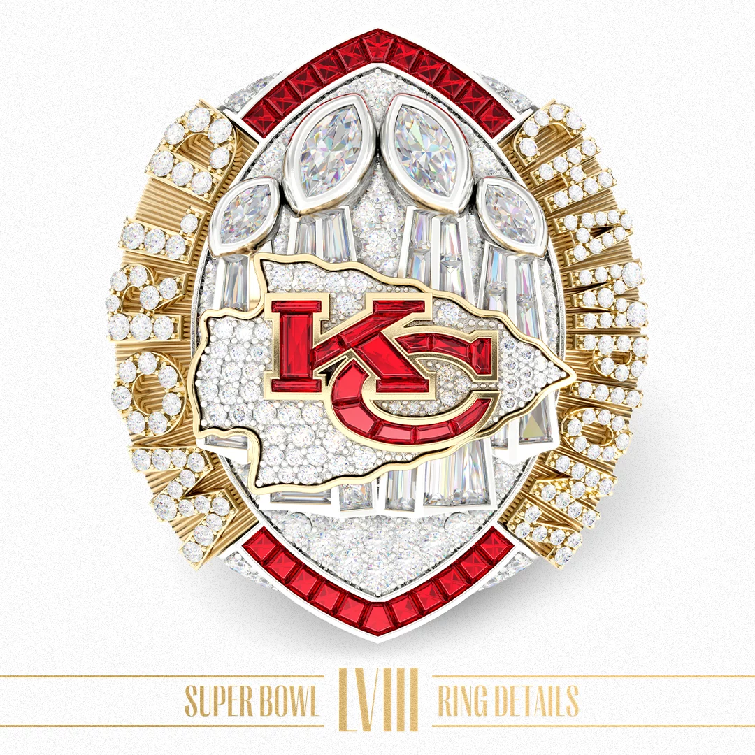 FootballR - NFL - Ein detaillierter Ring für den Super Bowl LVIII ist mit Diamanten und Gold verziert. In der Mitte ist das Logo der Kansas City Chiefs in Rot deutlich zu sehen. Der Ring weist komplizierte Designs und zahlreiche Edelsteine auf, darunter große, zeltförmige Diamanten oben. Darunter steht in Gold der Text „Super Bowl LVIII Ring Details“. Diese Beschreibung wurde automatisch generiert.