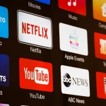 NFL in Brasilien - NFL Sunday Ticket - Auf einem Fernsehbildschirm werden verschiedene App-Symbole angezeigt, darunter Prime Video, Netflix, CBS Sports, YouTube und ABC News. Weitere sichtbare Symbole sind Filme, Musik, Computer, Trailer, Apple Events und das NFL Sunday Ticket-Logo – was die vielfältigen Multimedia-Optionen in der Streaming-Revolution hervorhebt. Diese Beschreibung wurde automatisch generiert.