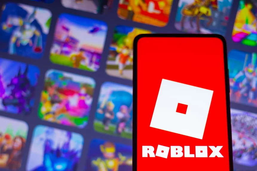 FootballR - NFL - Ein Smartphone mit dem Roblox-Logo, einem weißen, schrägen Quadrat mit einem kleineren, in der Mitte ausgeschnittenen Quadrat auf einem leuchtend roten Hintergrund. Hinter dem Telefon ist der Hintergrund verschwommen, zeigt aber bunte Spielsymbole, darunter NFL Universe Football, die verschiedene Auswahlmöglichkeiten auf der Roblox-Plattform hervorheben. Diese Beschreibung wurde automatisch generiert.