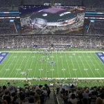 Markquese Bell - NFL - Klayton Adams - Eine Weitwinkelansicht des AT&T Stadium während eines Footballspiels der Dallas Cowboys. Das Spielfeld, umgeben von einer großen Zuschauermenge, zeigt das Sternenlogo der Cowboys an der 50-Yard-Linie und in jeder Endzone steht „Cowboys“. Während die kommende Saison näher rückt, machen die Fans aufgeregt NFL-Wetten, während sie das Spiel auf einem großen Bildschirm an der Decke verfolgen. Diese Beschreibung wurde automatisch generiert.