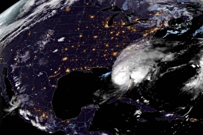 FootballR - NFL - Satellitenbild des Hurrikans Milton, der über den Südosten der USA zieht. Die wirbelnden weißen Wolken zeigen das Auge des Sturms in Küstennähe. Die USA sind von den Lichtern der Städte erhellt, wodurch besiedelte Gebiete wie die Heimat der Tampa Bay Buccaneers hervorgehoben werden, während die Erdkrümmung sichtbar ist. Diese Beschreibung wurde automatisch generiert.