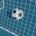 Ein Fußball liegt auf einem blauen Feld am weißen Tornetz. Die schwarz-weißen Felder, die dem klassischen Design eines Fußballs ähneln, bilden einen Kontrast zum Netz und der blauen Oberfläche und deuten auf ein erfolgreiches Tor hin. Sonnenlicht wirft weiche Schatten und betont die Texturen von Netz und Ball. Diese Beschreibung wurde mit der FootballR KI automatisch generiert.