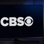 Ein Breitbildfernseher zeigt einen dunkelblauen Bildschirm mit dem weißen CBS-Logo, während die Spannung vor dem bevorstehenden Spiel Chiefs vs. Bills steigt. Die fettgedruckten „CBS“-Buchstaben und das ikonische Augensymbol fallen auf, während der schwach beleuchtete Hintergrund das elegante Design des Fernsehers betont. Diese Beschreibung wurde mit der FootballR KI automatisch generiert.