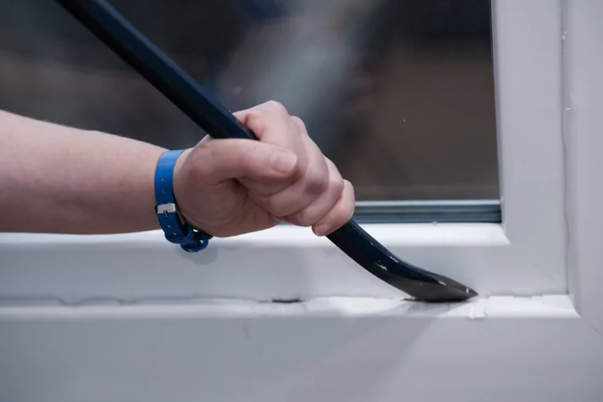 NFL warnt. Eine Hand mit einem blauen Armband benutzt ein Brecheisen, um die Unterseite eines weißen Fensterrahmens vorsichtig aufzubrechen und dabei sicherzustellen, dass kein Schaden entsteht. Diese Beschreibung wurde mit der FootballR KI automatisch generiert.