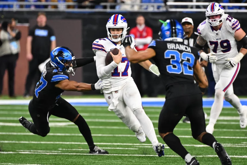 Josh Allen in weißer Uniform sprintet mit dem Ball, verfolgt von zwei Detroit Lions Spielern in schwarzen Trikots. Während ein Verteidiger nach ihm greift und ein anderer näher kommt, entfaltet sich das intensive Playoff Picture auf einem grünen Feld, wobei ein verschwommenes Publikum und andere Spieler die dramatische Szene noch verstärken. Diese Beschreibung wurde mit der FootballR KI automatisch generiert.