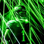 Predictions Week 11 - Eagles gegen Cowboys - NFL 2025 - Jalen Hurts mit Helm und Eagles-Trikot mit der Nummer 1 ist von grünen Laserstrahlen umgeben. Die elektrisierende Atmosphäre unterstreicht den konzentrierten Gesichtsausdruck des Spielers, während das Trikot stolz ein Adleremblem auf der Schulter zeigt, das an Jalen Hurts‘ dynamische Energie erinnert. Diese Beschreibung wurde mit der FootballR KI automatisch generiert.