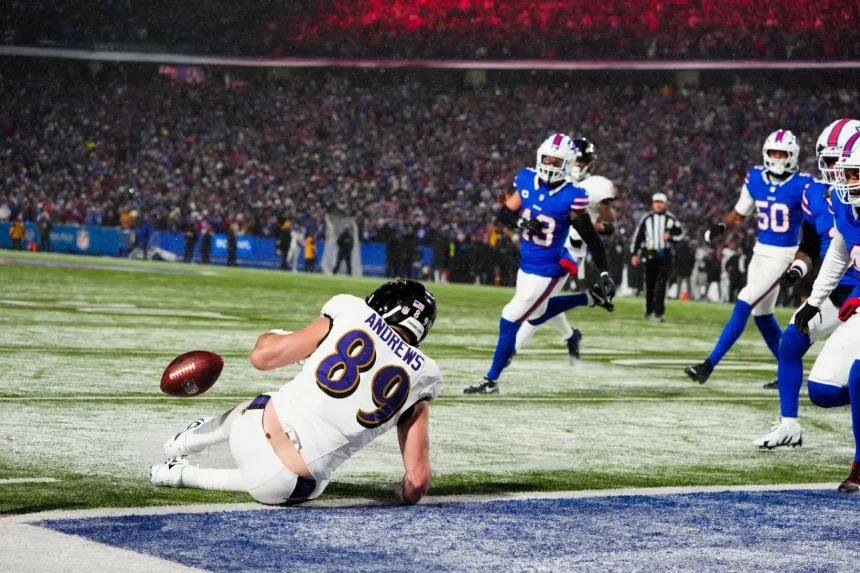 NFL Playoffs Divisional Round - Ein Footballspieler mit der Nummer 89 und der Aufschrift „ANDREWS“ hechtet in einem spannenden NFL-Playoff-Divisional-Round-Spiel in Richtung Endzone und streckt sich nach dem Ball, der gerade außer Reichweite ist. Spieler in blauen Trikots und ein Schiedsrichter sind im Hintergrund zu sehen, während die Zuschauer die Tribünen unter Stadionbeleuchtung füllen. Diese Beschreibung wurde mit der FootballR KI automatisch generiert.