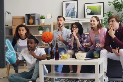 Gruppe von Freunden vor dem Fernseher im Wohnzimmer.