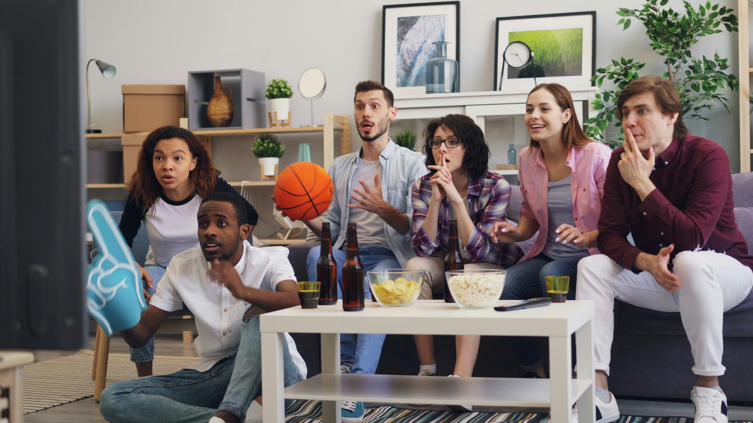 Gruppe von Freunden vor dem Fernseher im Wohnzimmer.