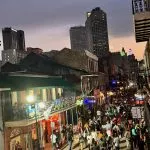 Super Bowl LIX - Eine geschäftige Straßenszene am Abend mit Menschenmassen, die eine belebte Stadtstraße entlanglaufen. Gebäude mit Balkonen sind mit bunten Lichtern und Schildern geschmückt, auf denen stolz Philadelphia Eagles-Banner zu sehen sind. Der Himmel ist bedeckt und im Hintergrund ragen die Wolkenkratzer der Stadt empor. Die Atmosphäre ist lebendig und festlich. Diese Beschreibung wurde mit der FootballR KI automatisch generiert.
