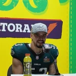 Zack Baun im Philadelphia Eagles-Trikot und mit Meisterschaftskappe spricht am Podium und freut sich sichtlich über den Sieg im Super Bowl. Vorne steht eine Gatorade-Flasche, während auf dem hellen Hintergrund das ikonische Gatorade-Logo prominent zu sehen ist. Diese Beschreibung wurde mit der FootballR KI automatisch generiert.