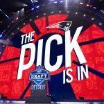 Compensatory Picks 2026 -Auf einer großen Bühne mit einem runden LED-Bildschirm wird neben dem Logo der New England Patriots „The Pick is In“ gezeigt. Football-Symbole schmücken den Hintergrund, während Hinweise auf den NFL Draft 2024 in Detroit und das Bud Light-Branding diesen spannenden Moment abrunden. Diese Beschreibung wurde mit der FootballR KI automatisch generiert.