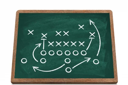 Defensive Fronts - Eine Tafel zeigt ein Spieldiagramm im American Football. X und O stehen für gegnerische Spieler, Pfeile veranschaulichen Bewegung, Verteidigungslinien und Strategie. Blocken, Laufen, Deckung und Passrouten sind mit weißer Kreide auf einer grünen, holzgerahmten Tafel skizziert. Diese Beschreibung wurde mit der FootballR KI automatisch generiert.