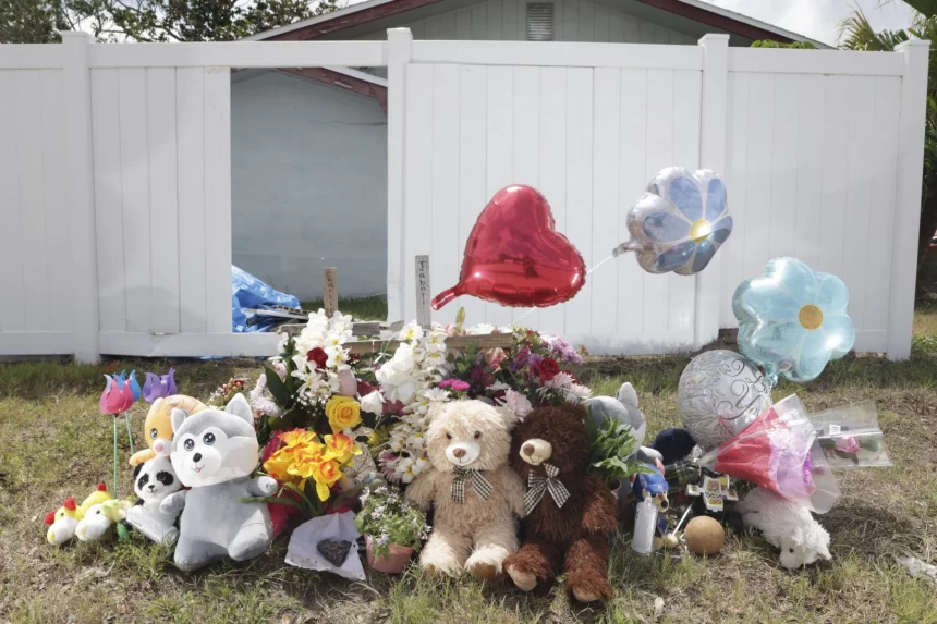 Miami Hurricanes Spieler in Unfall verwickelt: Ein Denkmal mit Teddybären, Stofftieren, Blumen und herz- und blumenförmigen Luftballons steht auf dem Rasen vor einem weißen Zaun und einem Haus – einige Gegenstände ehren die Verstorbenen mit herzlichen Botschaften der Erinnerung und des Beileids. Diese Beschreibung wurde mit der FootballR KI automatisch generiert.