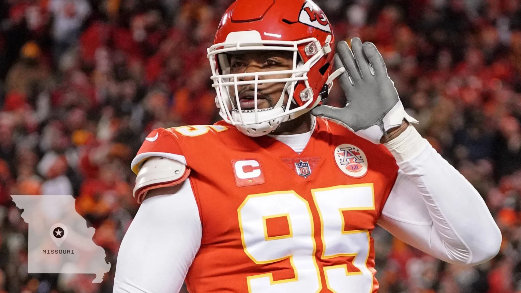 Chiefs und Royals - Ein Footballspieler im roten Trikot der Kansas City Chiefs (Nummer 95) hebt seine linke Hand ans Ohr, als würde er zuhören. Die verschwommene Stadionmenge deutet auf große Stadionprojekte hin. In der Ecke ist die Umrisslinie des Staates Missouri mit einem Stern und dem Schriftzug „MISSOURI“ zu sehen. Diese Beschreibung wurde mit der FootballR KI automatisch generiert.