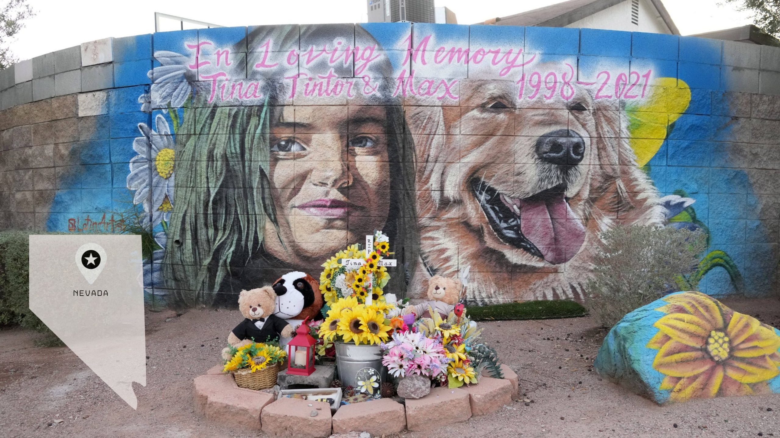 Ein Wandgemälde an einer Backsteinmauer zeigt ein Mädchen und einen Golden Retriever. Darüber steht „In liebevoller Erinnerung an Tina Tintor und Max 1998–2021“ – eine herzliche Hommage an die Tragödie um Henry Ruggs. Darunter befinden sich Blumen, Stofftiere, Kerzen und ein Foto. Unten links ist ein Nevada-Grabstein zu sehen. Diese Beschreibung wurde mit der FootballR KI automatisch generiert.
