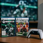 EA Footballkracher: Eine PlayStation 5-Konsole und ein Controller liegen auf einem Holztisch neben zwei EA-Fußballkracher-Spielen, "Madden 26" und "College Football 26". Der Fernseher im Hintergrund zeigt eine unscharfe Fußballspielszene. Diese Beschreibung wurde mit der FootballR KI automatisch generiert.