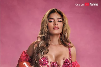 Karol G - Eine Frau in einem rosafarbenen Outfit versprüht Karol G-Vibes, während sie einen Fußball hält, bereit für ihren eigenen Halftime-Show-Moment. Diese Beschreibung wurde mit der FootballR KI automatisch generiert.