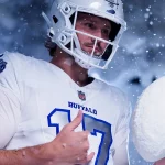 Josh Allen in einem weißen Buffalo NFL Rivalries-Trikot mit der Nummer 17 steht mit einem Helm im fallenden Schnee. Er hält einen großen Schneeball statt eines Footballs und schaut konzentriert, während Schneeflocken aufgewirbelt werden und eine winterliche Atmosphäre schaffen. Diese Beschreibung wurde mit der FootballR KI automatisch generiert.