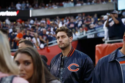 Jay Cutler in einer Jacke der Chicago Bears steht auf dem Football-Feld und blickt direkt in die Kamera, während hinter ihm Massen von Fans - einige mit Jay-Cutler-Trikots - das lebhafte Stadion füllen. Die Szene sprüht vor Energie und Bears-Stolz. Diese Beschreibung wurde mit der FootballR KI automatisch generiert.
