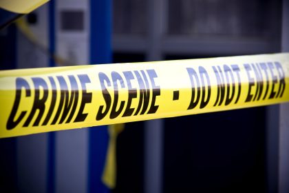 Nahaufnahme von leuchtend gelbem Tatortband mit der Aufschrift "CRIME SCENE - DO NOT ENTER". Das Klebeband markiert den eingeschränkten Zugang, mit einem unscharfen Gebäude und mehr gelbem Klebeband im Hintergrund, wo Mark Sanchez Berichten zufolge in der Nähe eines Krankenhauses festgenommen wurde. Diese Beschreibung wurde mit der FootballR KI automatisch generiert.