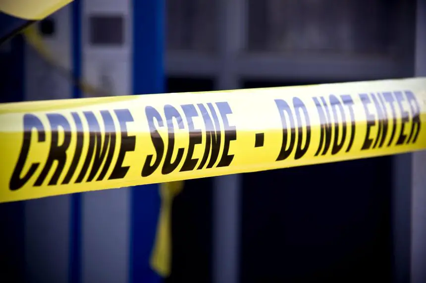 Nahaufnahme von leuchtend gelbem Tatortband mit der Aufschrift "CRIME SCENE - DO NOT ENTER". Das Klebeband markiert den eingeschränkten Zugang, mit einem unscharfen Gebäude und mehr gelbem Klebeband im Hintergrund, wo Mark Sanchez Berichten zufolge in der Nähe eines Krankenhauses festgenommen wurde. Diese Beschreibung wurde mit der FootballR KI automatisch generiert.