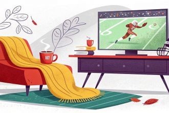 Black Friday Week - In einem gemütlichen Wohnzimmer stehen ein roter Sessel mit einer gelben Decke, eine dampfende Tasse und Bücher. Ein Fernseher zeigt einen Fußballspieler, der einen Pass fängt. Auf dem Fernsehtisch steht ein Fußballhelm. Laubdekorationen und Herbstblätter deuten auf ein Herbstsportthema hin. Diese Beschreibung wurde mit der FootballR KI automatisch generiert.