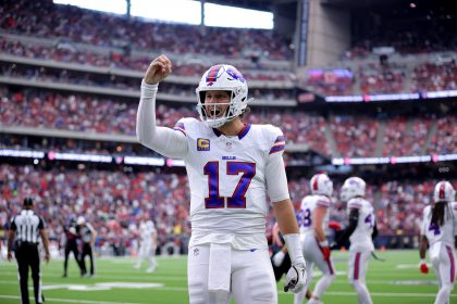 Josh Allen - Woche 11 - Ein Footballspieler im weißen Trikot der Buffalo Bills mit der Nummer 17 steht mitten im Spiel auf dem Feld und hebt die rechte Hand. In diesem Rückblick tragen das überfüllte Stadion und die Anwesenheit des Spielers der Woche zu einer spannenden Atmosphäre bei. Diese Beschreibung wurde mit der FootballR KI automatisch generiert.