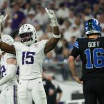 Ein Footballspieler in einem weiß-lila Trikot reißt auf dem Spielfeld feierlich beide Arme hoch. In der Nähe steht Detroit Lions Quarterback Goff mit der Nummer 16 mit dem Rücken zu den Fans, die das Stadion während der intensiven Playoff-Atmosphäre füllen. Diese Beschreibung wurde mit der FootballR KI automatisch generiert.