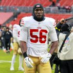 Keion White - Ein Footballspieler, der ein weiß-rotes 49ers-Trikot mit der Nummer 56 trägt, steht nach einem Spiel auf dem Feld und erinnert an Keion Whites entschlossenes Auftreten. Alt-Text wurde KI-generiert.