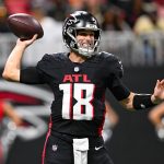 Ein Football-Spieler im Trikot der Atlanta Falcons mit der Nummer 18 bereitet sich darauf vor, während eines Spiels einen Football zu werfen, was die dynamische Energie des Teams auch nach der Verpflichtung von Kirk Cousins unterstreicht. Alt-Text wurde KI-generiert.
