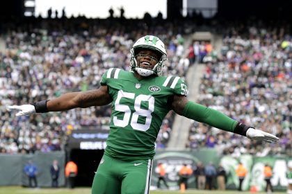 Darron Lee, Linebacker der New York Jets, trägt die Nummer 58 und steht während eines Spiels mit ausgestreckten Armen auf dem Spielfeld. Alt-Text wurde KI-generiert.