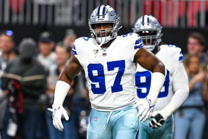 Der Dallas Cowboys-Footballspieler Osa Odighizuwa, der die Trikotnummer 97 trägt, steht während eines Spiels auf dem Spielfeld, während ein anderer Spieler und Zuschauer im Hintergrund zu sehen sind. Alt-Text wurde KI-generiert.