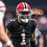 Der Footballspieler Darnell Mooney in einem schwarzen Trikot der Atlanta Falcons mit rotem Helm und der Nummer 1 steht während eines Spiels auf dem Spielfeld. Alt-Text wurde KI-generiert.