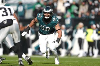 Jaelan Phillips - Ein Footballspieler in einem grünen Philadelphia Eagles-Trikot mit der Nummer 50 läuft während eines Spiels gegen die Las Vegas Raiders über das Spielfeld und erinnert an den dynamischen Stil von Jaelan Phillips. Alt-Text wurde KI-generiert.