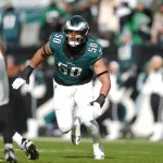 Jaelan Phillips - Ein Footballspieler in einem grünen Philadelphia Eagles-Trikot mit der Nummer 50 läuft während eines Spiels gegen die Las Vegas Raiders über das Spielfeld und erinnert an den dynamischen Stil von Jaelan Phillips. Alt-Text wurde KI-generiert.