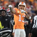 Footballspieler Mike Evans in orangefarbenem Trikot mit Nummer 13 feiert Geste, Schiedsrichter und Zuschauer im Hintergrund