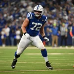 Braden Smith - Offensive Tackle im blauen Trikot der Indianapolis Colts, Nummer 72, bereitet sich während eines Spiels auf einem grünen Feld mit einer Menschenmenge im Hintergrund auf den Block vor; er wird 2026 in die Free Agency eintreten. Alt-Text wurde KI-generiert.